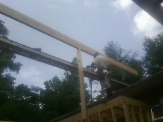 Carpenter setting a ridge beam over a new addition frame — Ice Dam Removal by Roofing Brothers in Thorn Hill