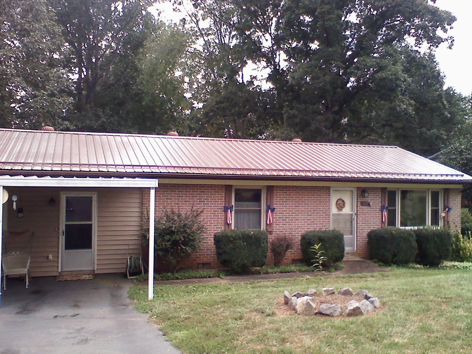 Bronze metal roof and carport on a brick ranch home — Roof Repair work by our crew in Thorn Hill
